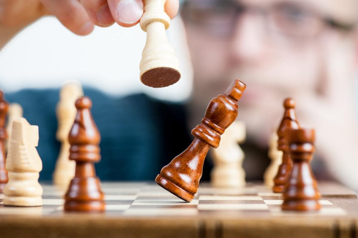 Person playing with chess pieces