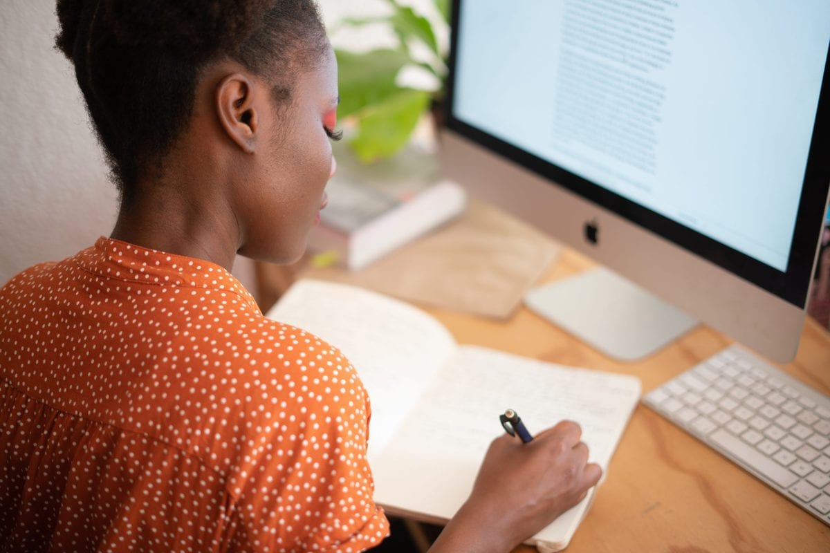 female in orange shirt working