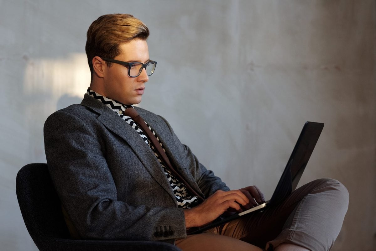 man in suit using laptop