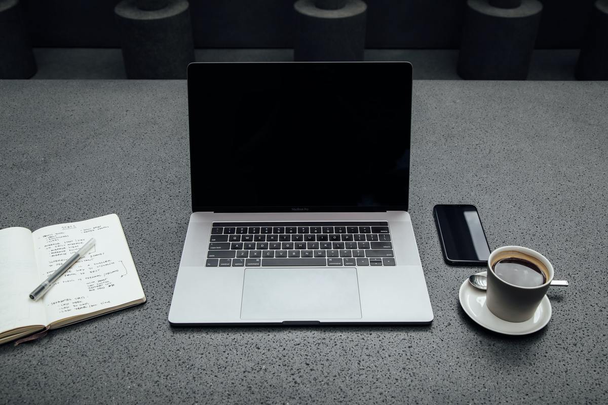 laptop and cup of coffee on grey table